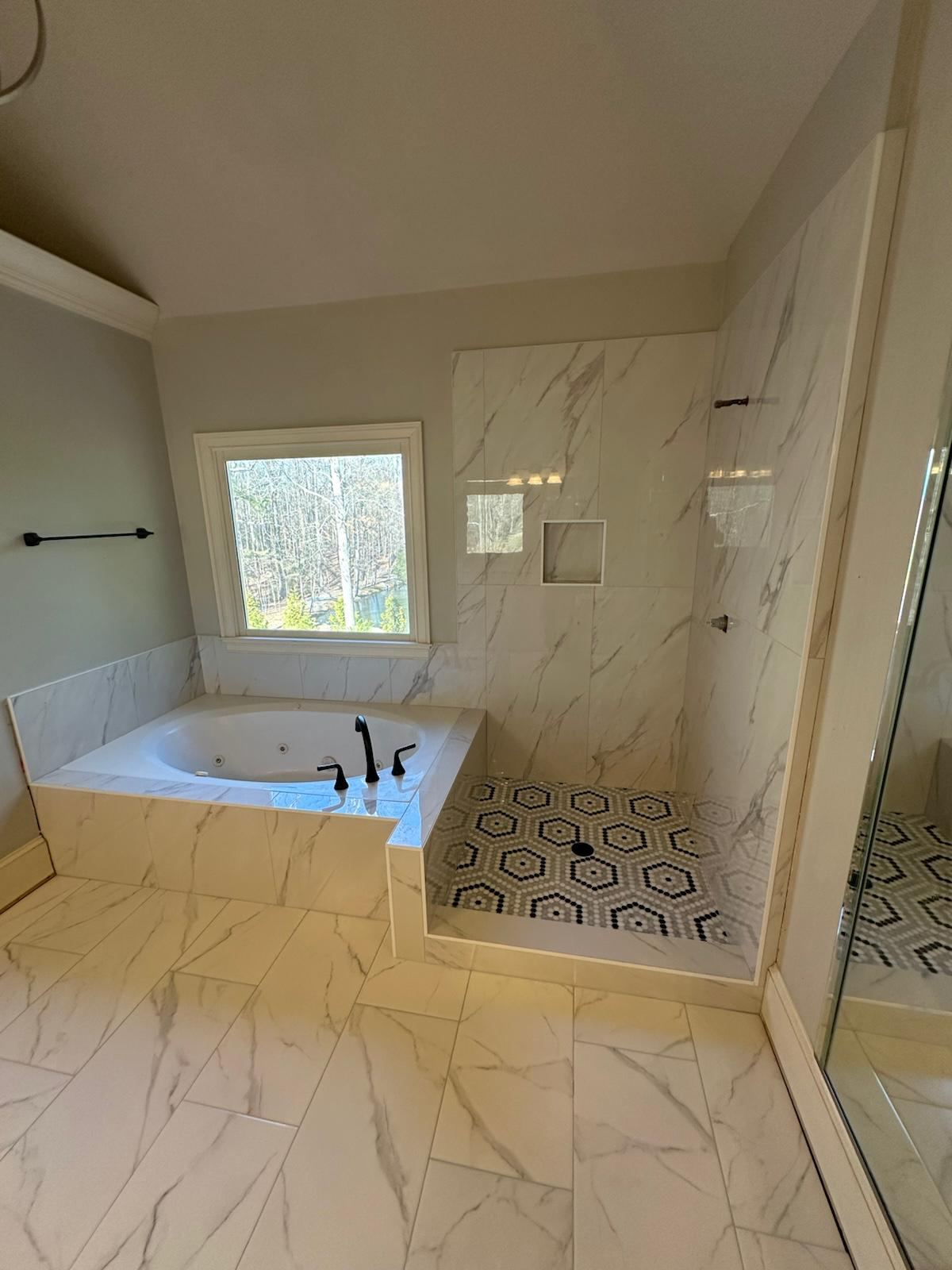 Finished marble bathroom with soaking tub and glass shower installed by TCS Tile Company