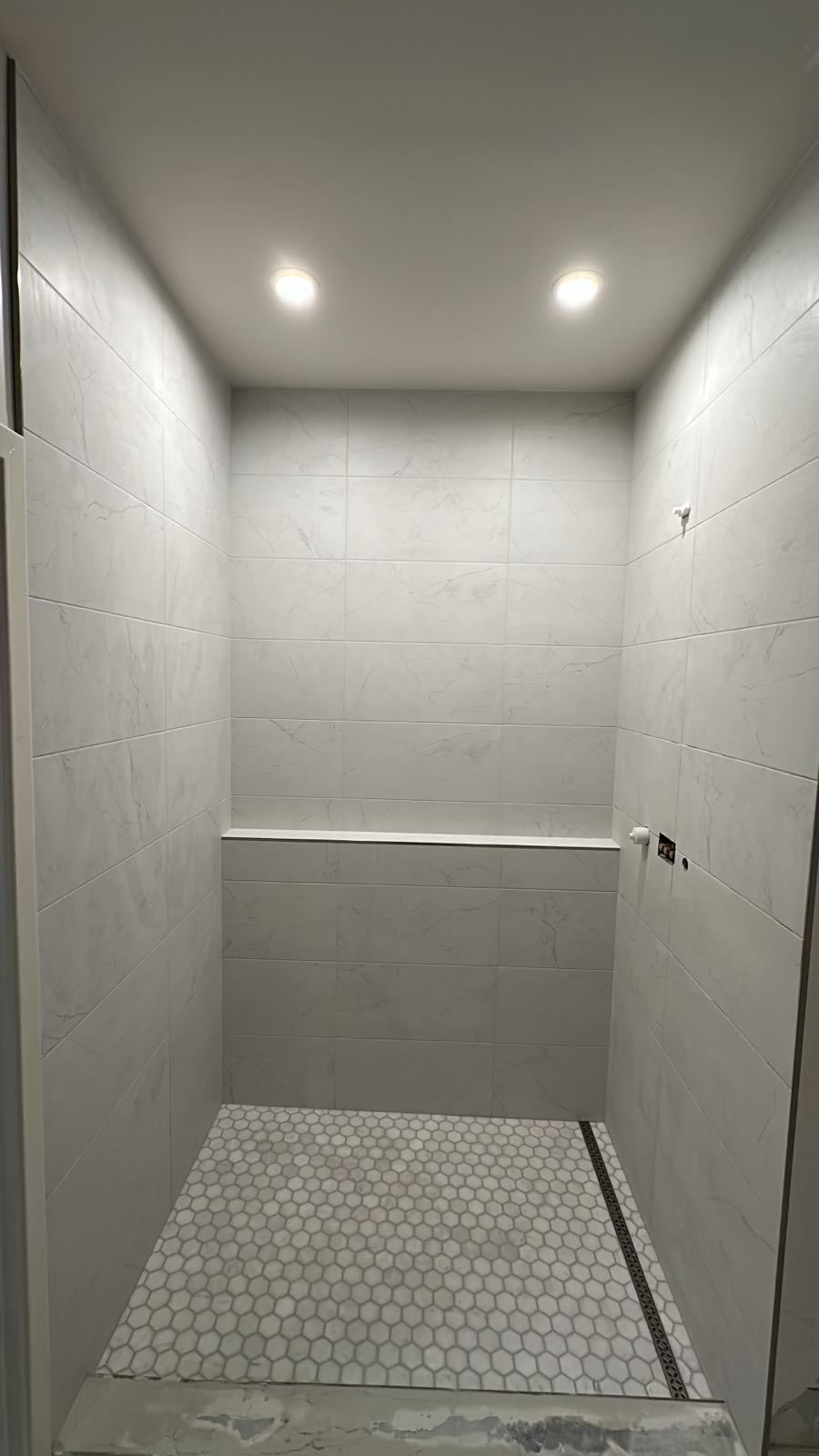 Charcoal vertical tile shower with dramatic lighting