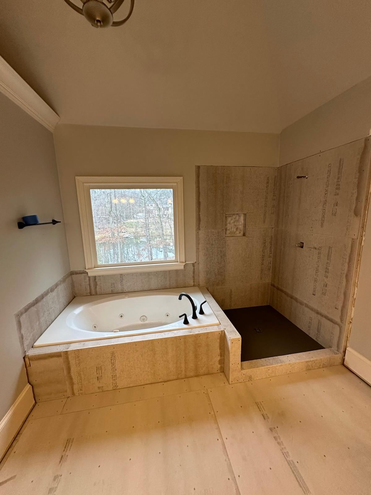 Marble-look tub and shower surround with mosaic floor accent